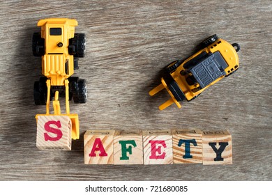 Toy Plastic Bulldozer Hold Toy Block Letter S To Fulfill Word Safety With Forklift On Wood Background