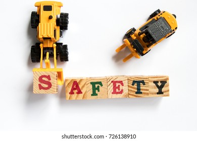 Toy Plastic Bulldozer Hold Toy Block Letter S To Fulfill Word Safety With Forklift On White Background