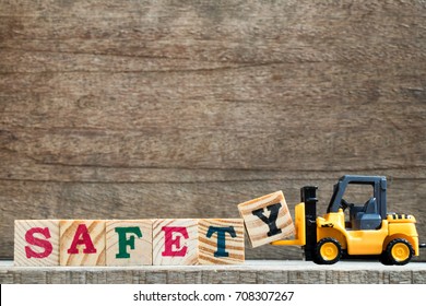 Toy plastic forklift hold block Y to compose and fulfill wording safety on wood background - Shutterstock ID 708307267