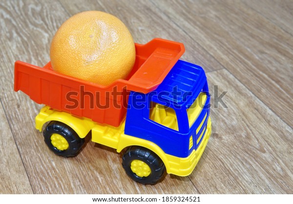 Toy plastic multi-colored truck loaded with
ripe grapefruit. The concept of delivering grapefruit from producer
to consumer.