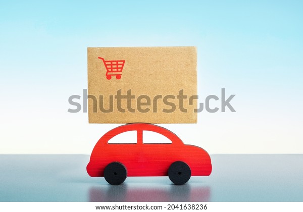  Toy red car with box on blue background. 
Logistic and delivery concept.
