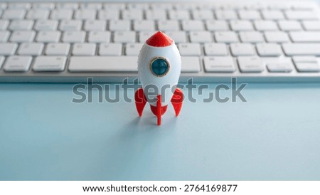 Toy rocket on a computer keyboard representing fast internet speed and startup business launch.