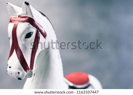Toy rocking white horse on a dark background, close up.