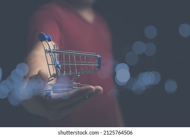 Toy shopping cart empty on man hand with copy space for text or design. sale, discount, shopping online concept. Consumer society trend.