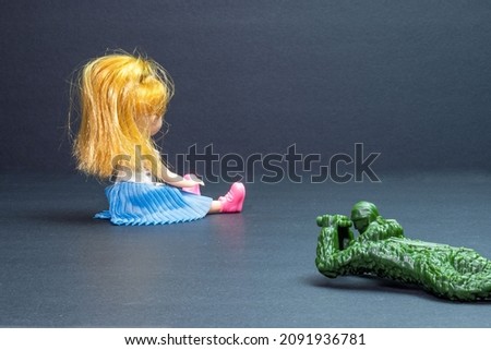 toy soldier looks through binoculars and guards a beautiful doll. space for printing. background picture.