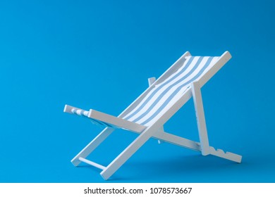 Toy Sun Bed On Clean Blue Background Symbolizing Summer Vacation At The Sea