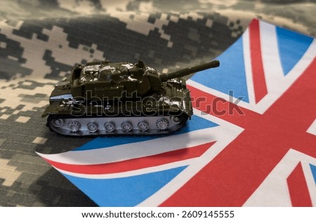 Toy tank with British flag on green background