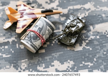 toy tank on the background of dollar bills