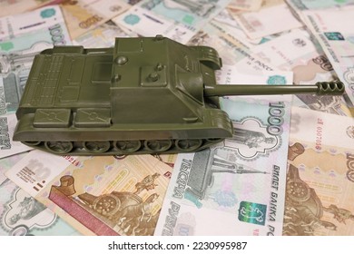 toy tank on russian banknotes roubles, war conflict russia ukraine, sanctions, crisis concept