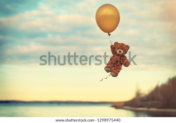 teddy bear flying with balloons