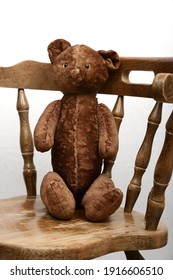 Toy Teddy Bear Sitting In An Old Vintage Wooden Armchair