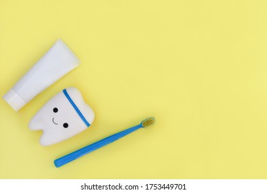 Toy Tooth, Toothbrush And Toothpaste On Yellow Background. Poster For Stomatology, Dentist Office Or Denal Care Clinic. Kids Oral Hygiene. Copy Space For Advertising Or Text