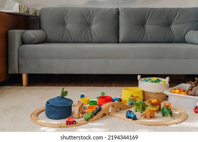 A Toy Town With Wooden Railway And Toy Animals Built In A Children's Room. Toy Train Locomotive, Wooden Blocks, Toy Animals And Storage Baskets. Educational Game For Toddler In Modern Nursery.