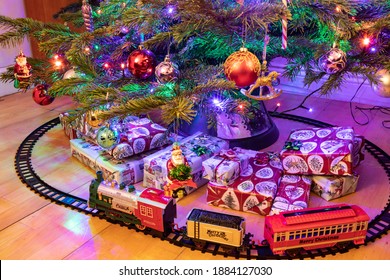 A Toy Train Under A Christmas Tree.