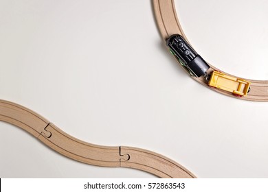 Toy Train And Wooden Rails On White Background. Top View. Copy Space For Text