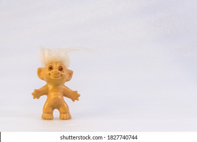 Toy troll with white hair and white background with copy space