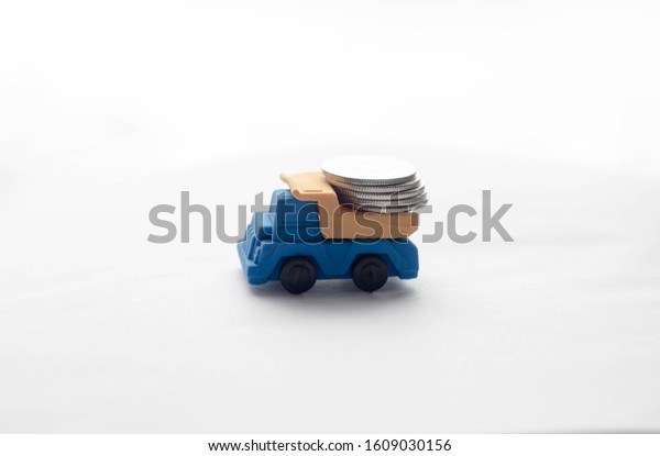 Toy truck carrying coins. Blue truck in the back
carrying silver coins