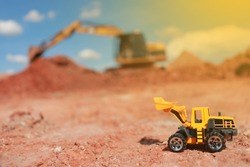 Toy Truck And Construction Machinery Yellow And Green With Sand And Soil Pile Of Stones  Red On Rough Area Red And The Pile Of Construction Machinery Is Working Construction Concept Environment 