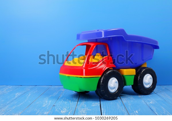 Toy truck
dump truck on a blue wooden
background.