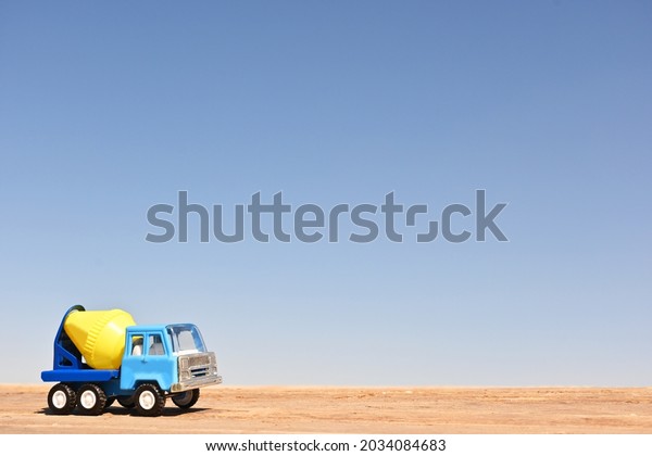 Toy truck mixer. Collectible at scale.\
Wood floor and blue sky background.\
Macro