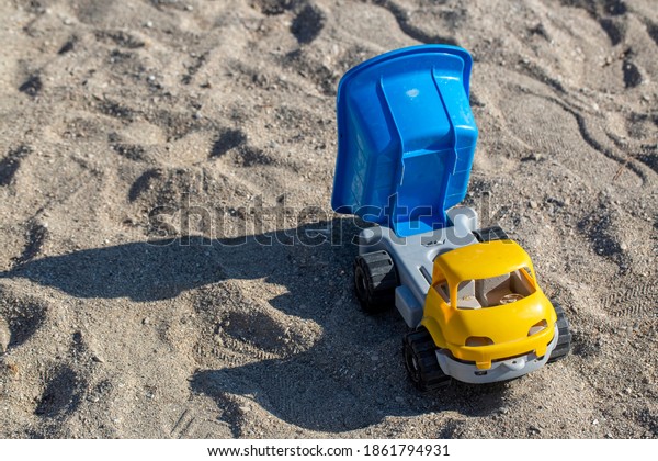 Toy truck on sea\
sand