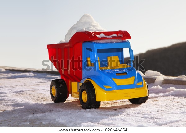 toy truck\
removes snow on the road in\
winter