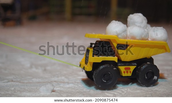 toy truck with
snowballs in the snow at
night.