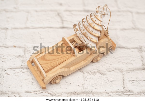 toy wooden car carry\
the Christmas tree