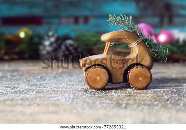 Toy wooden car with tree branches against the\
background of an o
