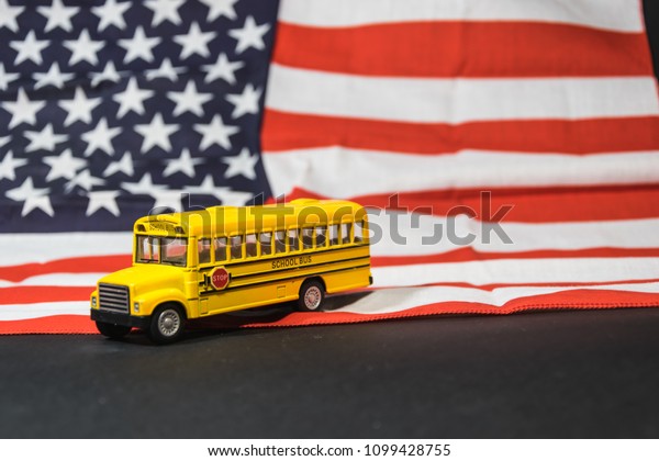 toy yellow school bus and\
US flag