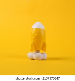 Toy yellow space shuttle or rocket on yellow background. Minimalism, conceptual pop, fresh idea or startup