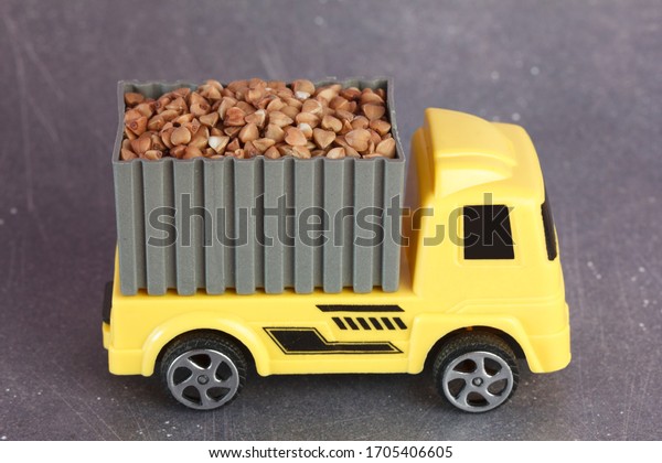 Toy yellow truck with buckwheat.  Buckwheat\
transportation concept.
