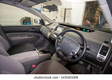 Toyota Prius Hybrid 2014 Interior. Catalytic Converter Stolen By Criminals For Scrap Parts. Interior Of Car In Mechanics Garage. UK, Vehicle Damage Editorial Background.