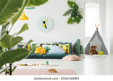 Toys And Clock In Bright Kid's Room Interior With Teepee And Teddy Bear In Front Of Window