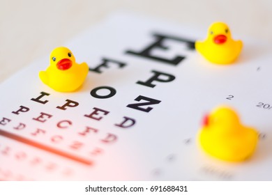 Toys Duck On The Blurred Eye Sight Test Chart Background Close Up - Kids Vision Check Concept