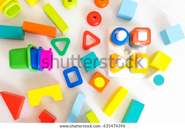 toys kids background.\
Wooden cubes with numbers and colorful toy bricks on a white\
background. frame made of accessories for children on old table.\
top view. copy space.