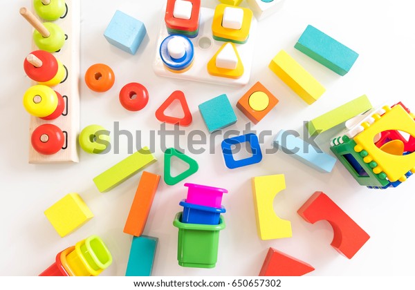 toys kids background. Wooden cubes with numbers and\
colorful toy bricks on a white background. frame made of\
accessories for children. top\
view.