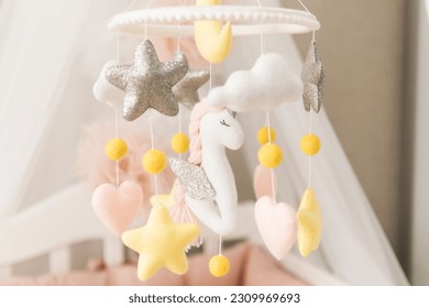 Toys over the crib. A mobile baby cot with stars, clouds and a unicorn. - Powered by Shutterstock