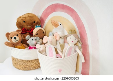 Toys and rag dolls in cloth stylish baskets on the table. Beige Toy Storage Baskets  in the children's room. Organizing and Storage Ideas in nursery.  House cleaning.