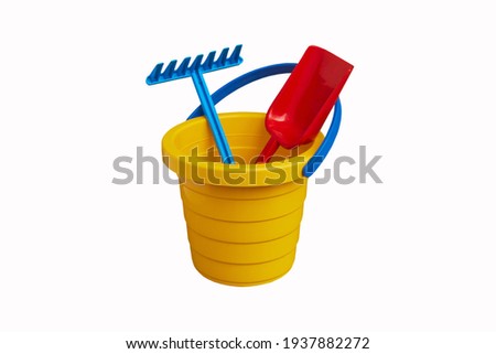 toys for sand,yellow bucket with a shovel and a rake isolated on a white background