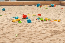 Toys Are Scattered In A Large Children's Sandbox. Childhood And Leisure Of Kids