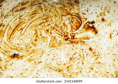 Traces Of Sauce On The Plate After Eating. Brown Streaks On A White Background. The Texture Of Dirty Stains On The Surface Of Dishes