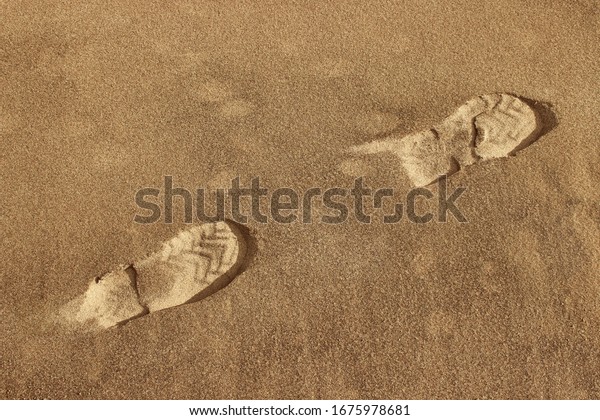 Traces of shoes in the sand. Footprints in the
sandy ground.