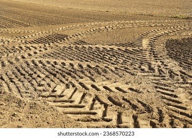 traces of tractor wheels in the sand, traces of a tractor, a tractor plows a field, autumn work in a field, tractor in a field, dry earth with traces, traces of a car, relief, soil in  - Shutterstock ID 2368570223