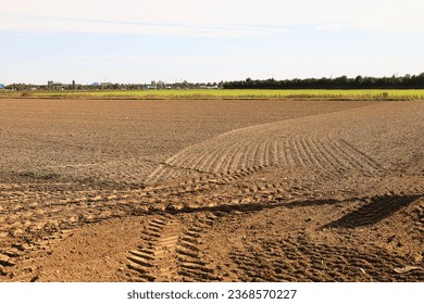 traces of tractor wheels in the sand, traces of a tractor, a tractor plows a field, autumn work in a field, tractor in a field, dry earth with traces, traces of a car, relief, soil in  - Shutterstock ID 2368570227