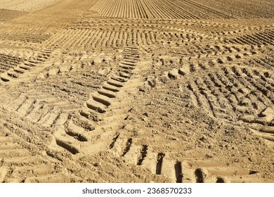 traces of tractor wheels in the sand, traces of a tractor, a tractor plows a field, autumn work in a field, tractor in a field, dry earth with traces, traces of a car, relief, soil in  - Shutterstock ID 2368570233