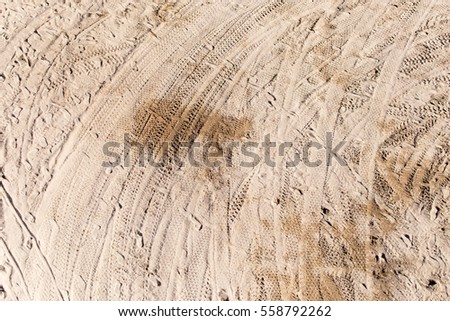 traces of wheels on the sand as a background