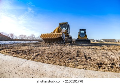Track Bulldozer, Earth-moving Equipment At Construction Site With Bright Blue Sky Background. Land Clearing, Grading, Ground Excavation, Foundation Digging Of Large Job Of New Residential Building.
