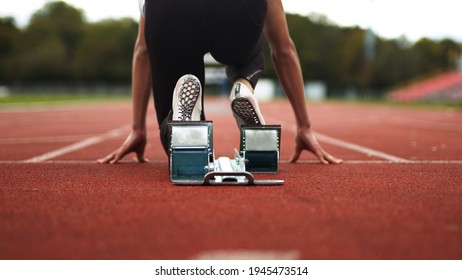 Track and Field Athlete being ready in the blocks alone with no competition, sprinter, empty lanes, lonely, training, practise, spikes