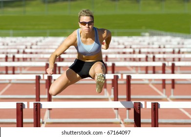 Track And Field Athlete Jumps Over Hurdles.